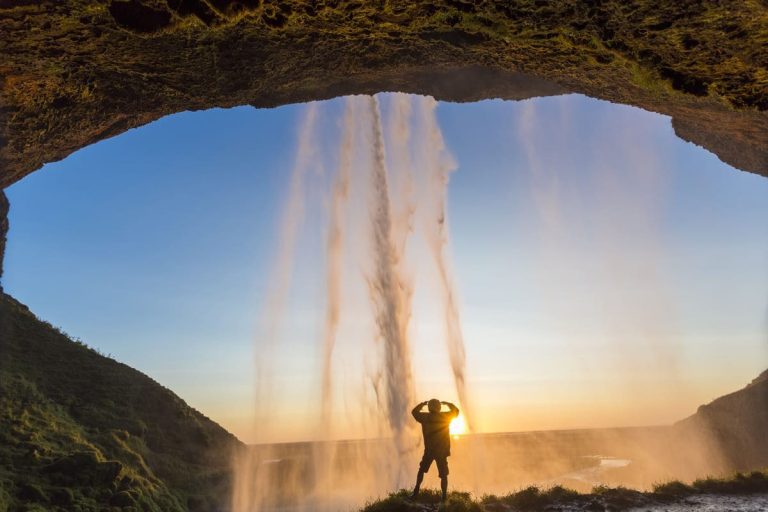 rear-view-of-man-standing-underneath-natural-arch-2023-11-27-05-27-25-utc
