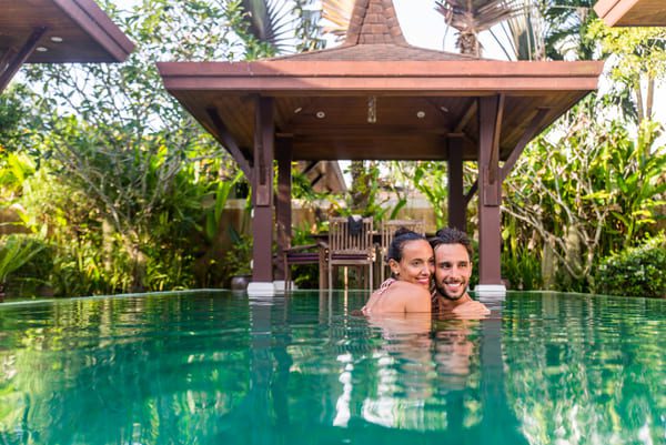 a couple smiling and hugging in a beautiful pool