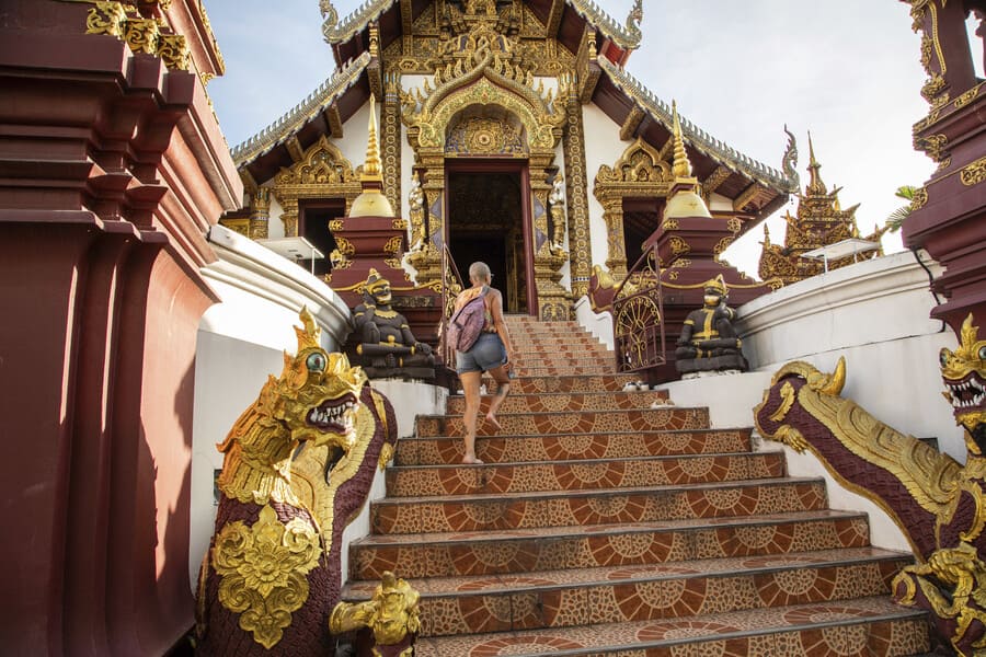 a woman exploring lush tropical gardens in Thailand, enjoying a bespoke luxury travel experience.