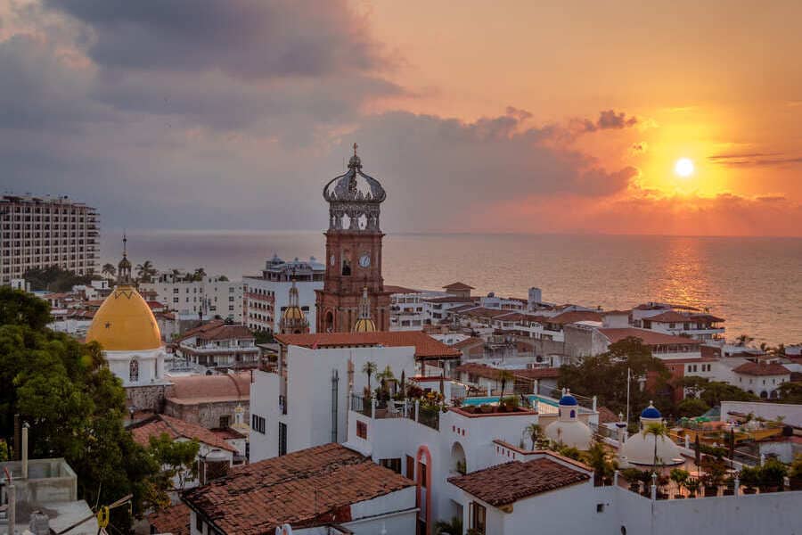 Sunset over the historic centre of Puerto Vallarta, Mexico, featuring the iconic Church of Our Lady of Guadalupe and the Pacific coastline.